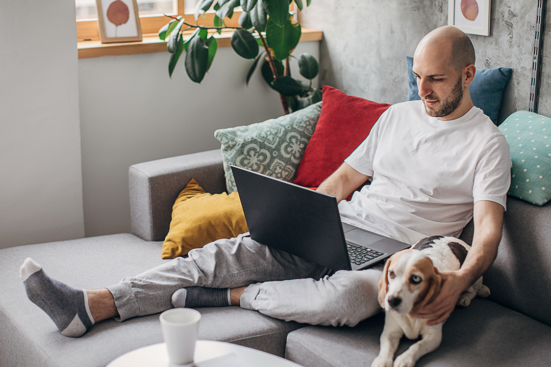 man sitting on couch with dog